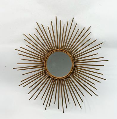 a gold sunburst mirror on a white wall