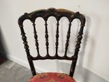 a wooden chair with a red cushion on it
