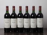 six bouteilles de vin sont alignées sur une table en bois