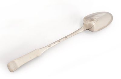 cuillère en argent avec un manche, sur fond blanc, posée sur une surface blanche