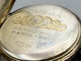 a gold pocket watch sitting on top of a table