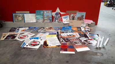 beaucoup de livres par terre, près d'un mur rouge