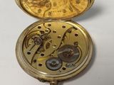 a gold pocket watch with a chain hanging from it ' s side