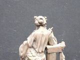 a statue of a woman sitting on a chair