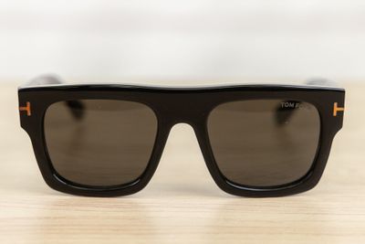 a pair of black sunglasses sitting on top of a wooden table