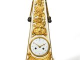 une horloge en or surmontée d'un oiseau
