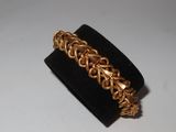a close up of a gold bracelet on a black ring