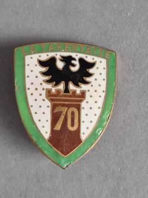 un gros plan d'un insigne représentant un aigle perché au sommet d'une tour