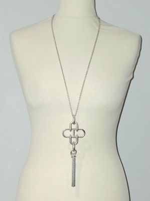 necklace with a cross and a key on a mannequin torso