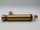 a brass plated metal pipe with a white cap on a white surface