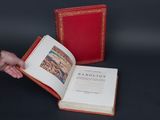 someone is holding a book with a red cover and a black background