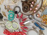 many different necklaces and bracelets on the table