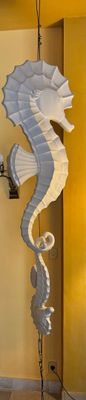 une sculpture représentant un hippocampe, posée sur un socle dans une pièce