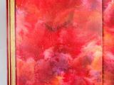 an open book with a painting of a red sky and clouds on it