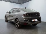 the rear end of a grey car in a white room