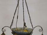 an old fashioned chandelier hanging from a ceiling with three yellow glass lamps