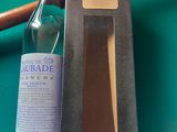 a bottle of alcohol next to a knife on a pool table