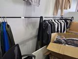 beaucoup de vêtements suspendus à une étagère dans une pièce