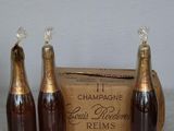 three bottles of champagne sitting next to a cardboard box on a table