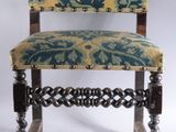 une vieille chaise en bois dont l'assise est recouverte d'un tissu bleu et jaune
