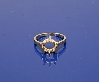 une bague en or posée sur une surface bleue