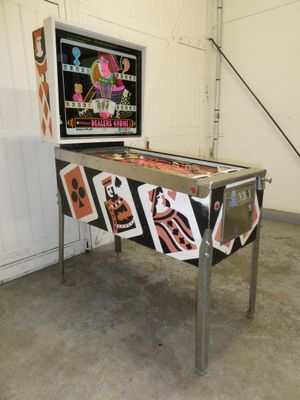 a pinball machine in a room with a lot of stickers on it