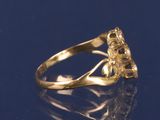 a gold ring with a flower on it on a blue surface
