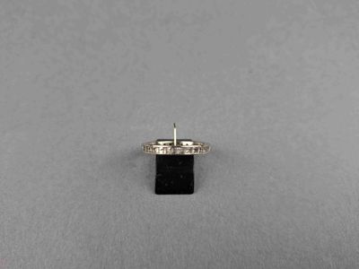 un gros plan d'une bague sertie d'un diamant et d'une pierre noire sur une surface grise