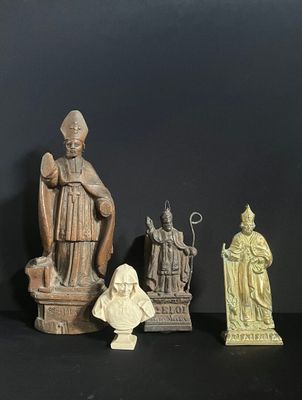 three figurines of a man and a woman sitting on top of a table