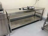 une table de travail en acier inoxydable sur laquelle sont posés deux téléphones, dans une cuisine
