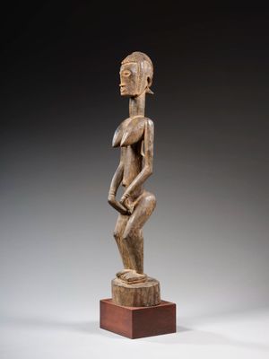 une statue en bois d'un homme avec un chapeau sur la tête