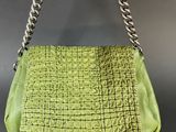 a green purse with a chain hanging from it