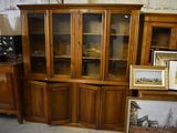 a wooden cabinet with glass doors and pictures on it