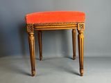 une banquette rembourrée de couleur orange, avec une structure et des pieds en bois
