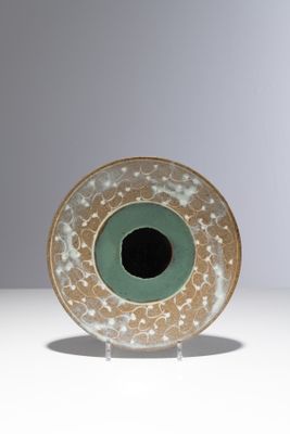 une assiette verte et blanche avec un trou noir au centre