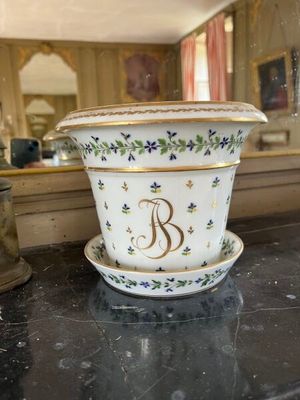 un pot de fleurs blanc posé sur une table