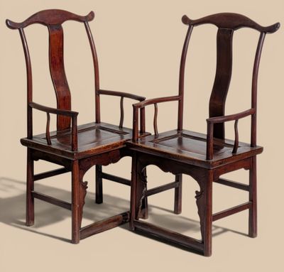 two wooden chairs with arms and backs are sitting side by side