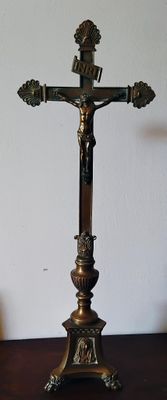 un crucifix posé sur une table, avec une bougie dessus