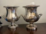 pair of silver plated urns on wooden table in room