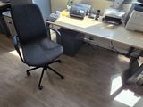 a desk with a chair and a printer on it