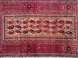 a red rug with a floral design on a white background