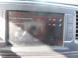 a picture of a car dashboard with a dog in the background