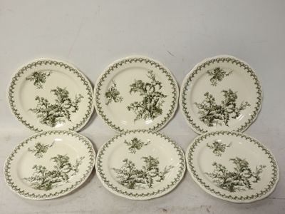six assiettes vertes et blanches ornées d'oiseaux, posées sur une table