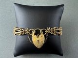 a close up of a black pillow with a gold heart lock on it