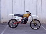 a dirt bike parked in a parking lot near a wall