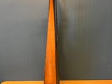 a wooden instrument on a table against a gray wall