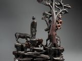 an image of a sculpture of a man and a dog on a rock