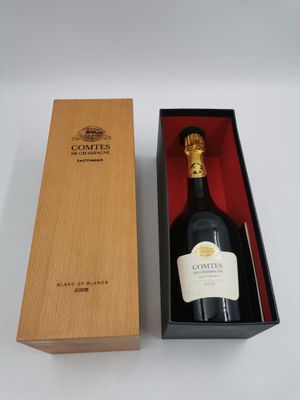 une bouteille de vin vide dans une caisse en bois posée sur une surface blanche