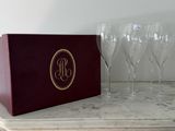 quatre verres à vin posés sur une table, à côté d'une boîte