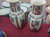 many vases and plates on a table with a red table cloth